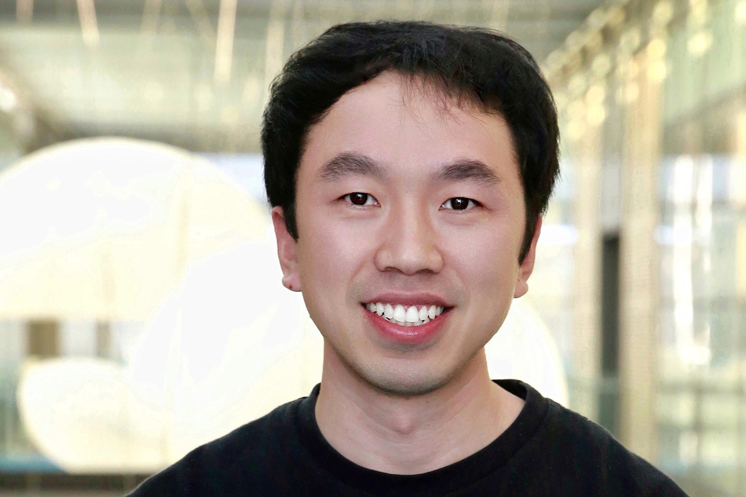 Researcher stands in a dark colored shirt in an outdoor setting